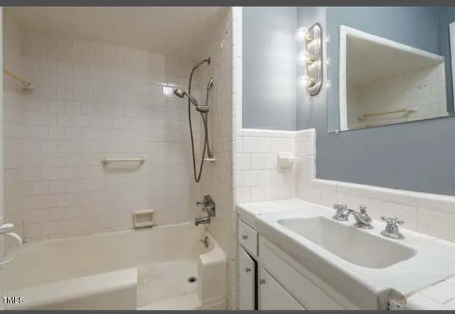 a bathroom with a tub sink and mirror