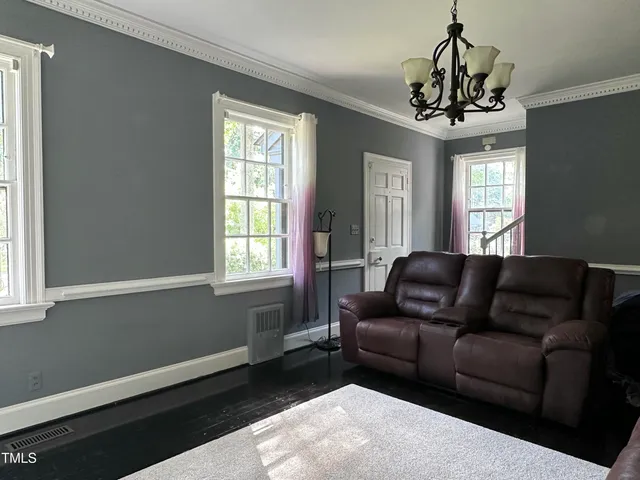 a living room with furniture and a chandelier