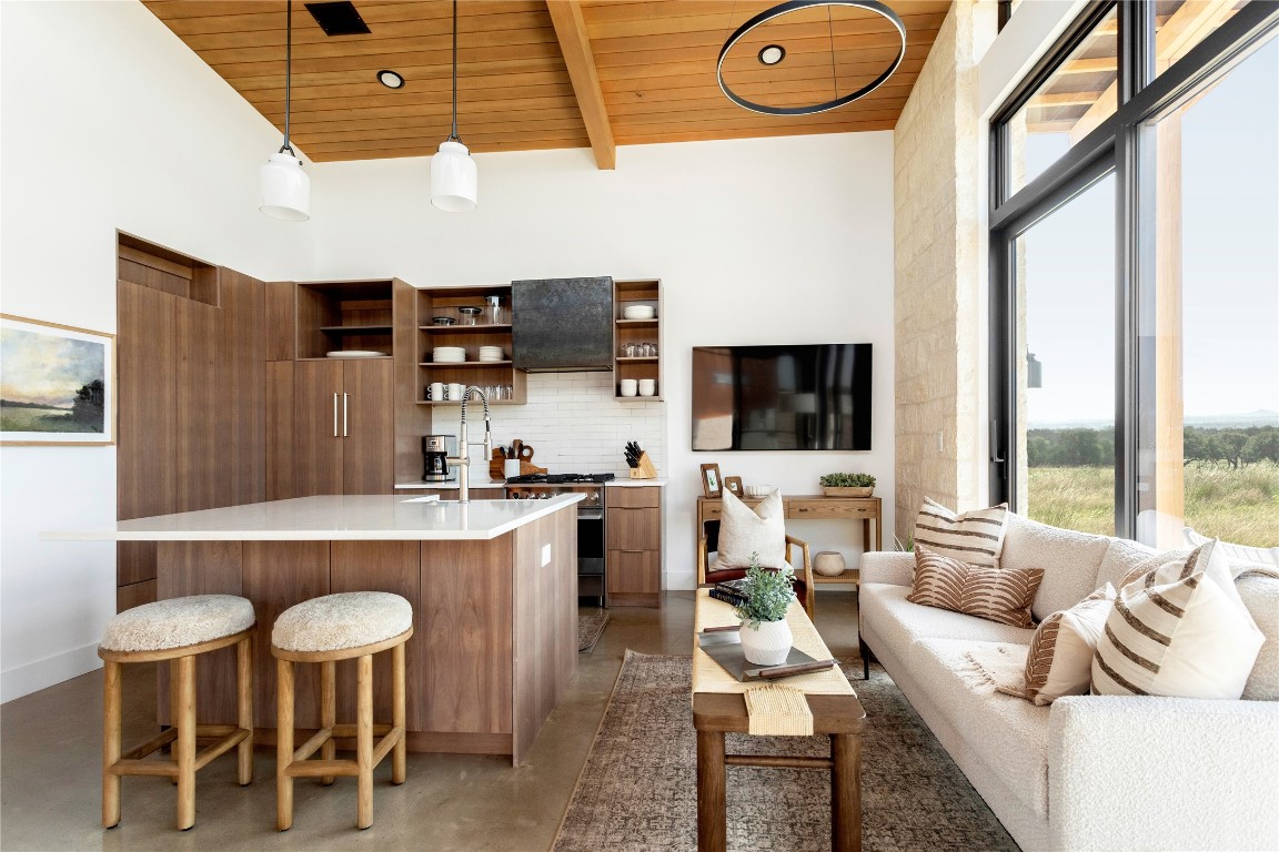 a living room with furniture a flat screen tv and a floor to ceiling window
