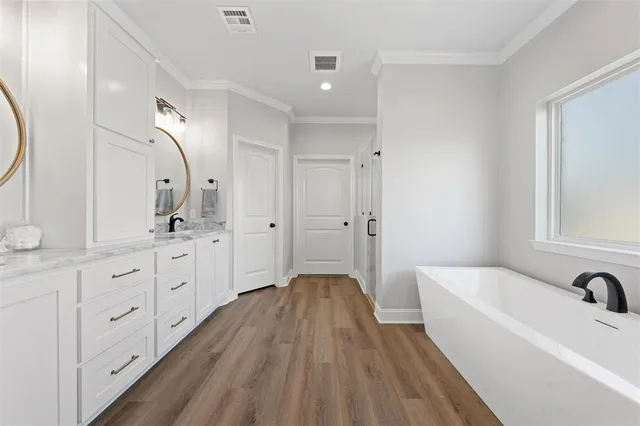 a bathroom with a tub sink and mirror