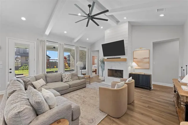 a living room with furniture a fireplace and a flat screen tv