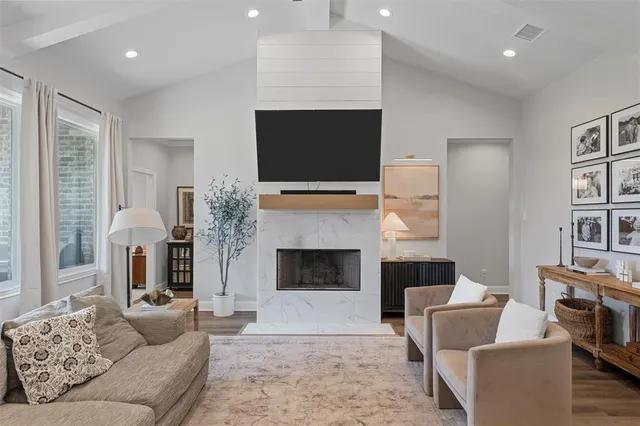 a living room with furniture a flat screen tv and a fireplace