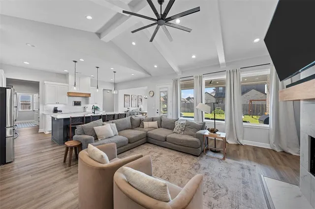 a living room with furniture and a view of kitchen