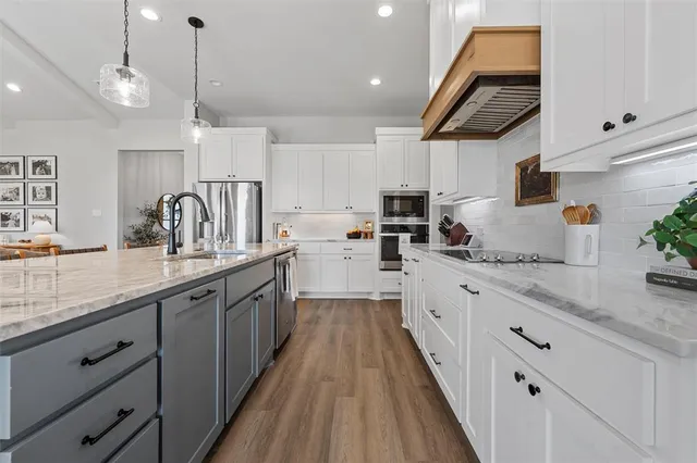 a kitchen with stainless steel appliances kitchen island granite countertop a sink and cabinets