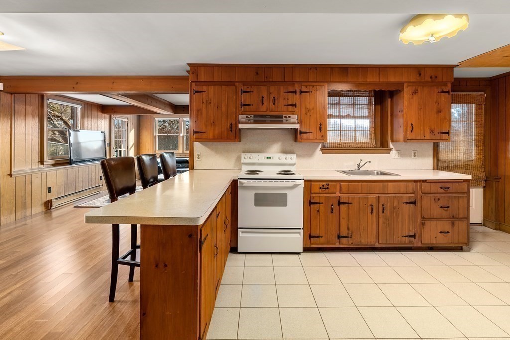 1140 Webster Street Needham, MA 02492 - Photo 24 of 27 a kitchen with a stove a sink a dining table and chairs