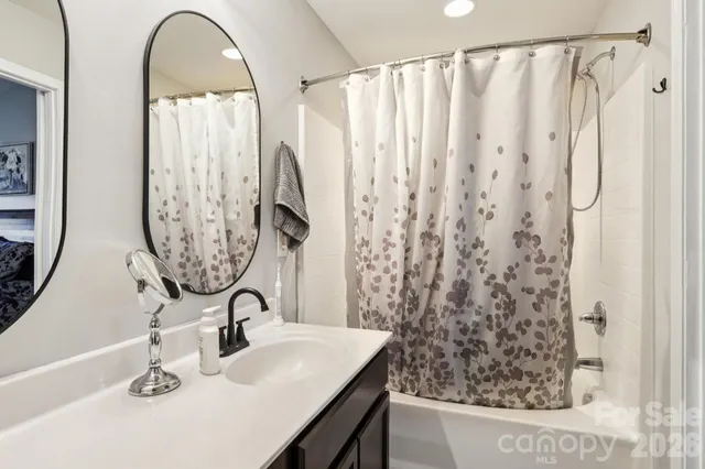a bathroom with a sink a mirror and a shower curtain