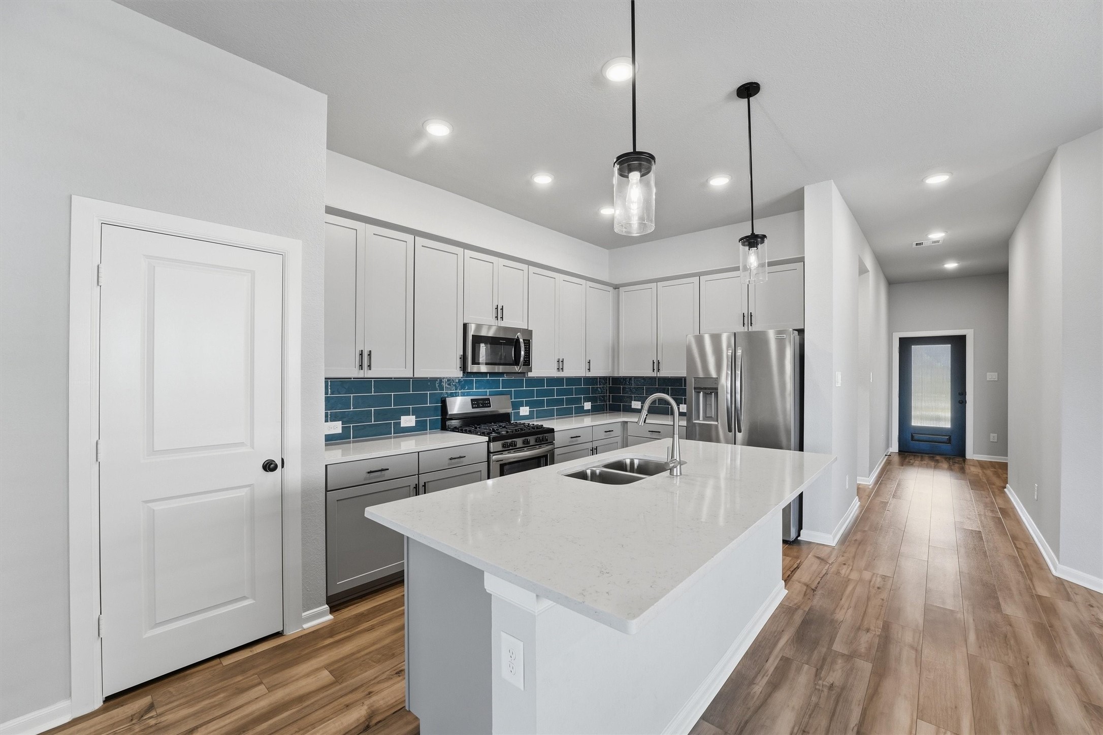 1338 Lakeside Crk Road Magnolia, TX 77354 - Photo 11 of 37 a kitchen with stainless steel appliances kitchen island granite countertop a refrigerator a sink dishwasher a stove and white cabinets with wooden floor