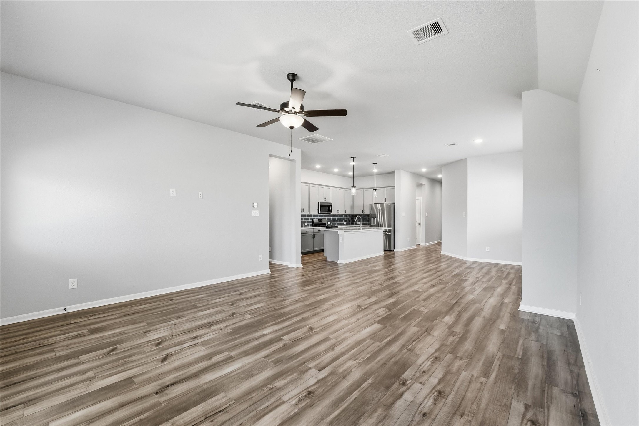 1338 Lakeside Crk Road Magnolia, TX 77354 - Photo 18 of 37 a view of kitchen and empty room with wooden floor