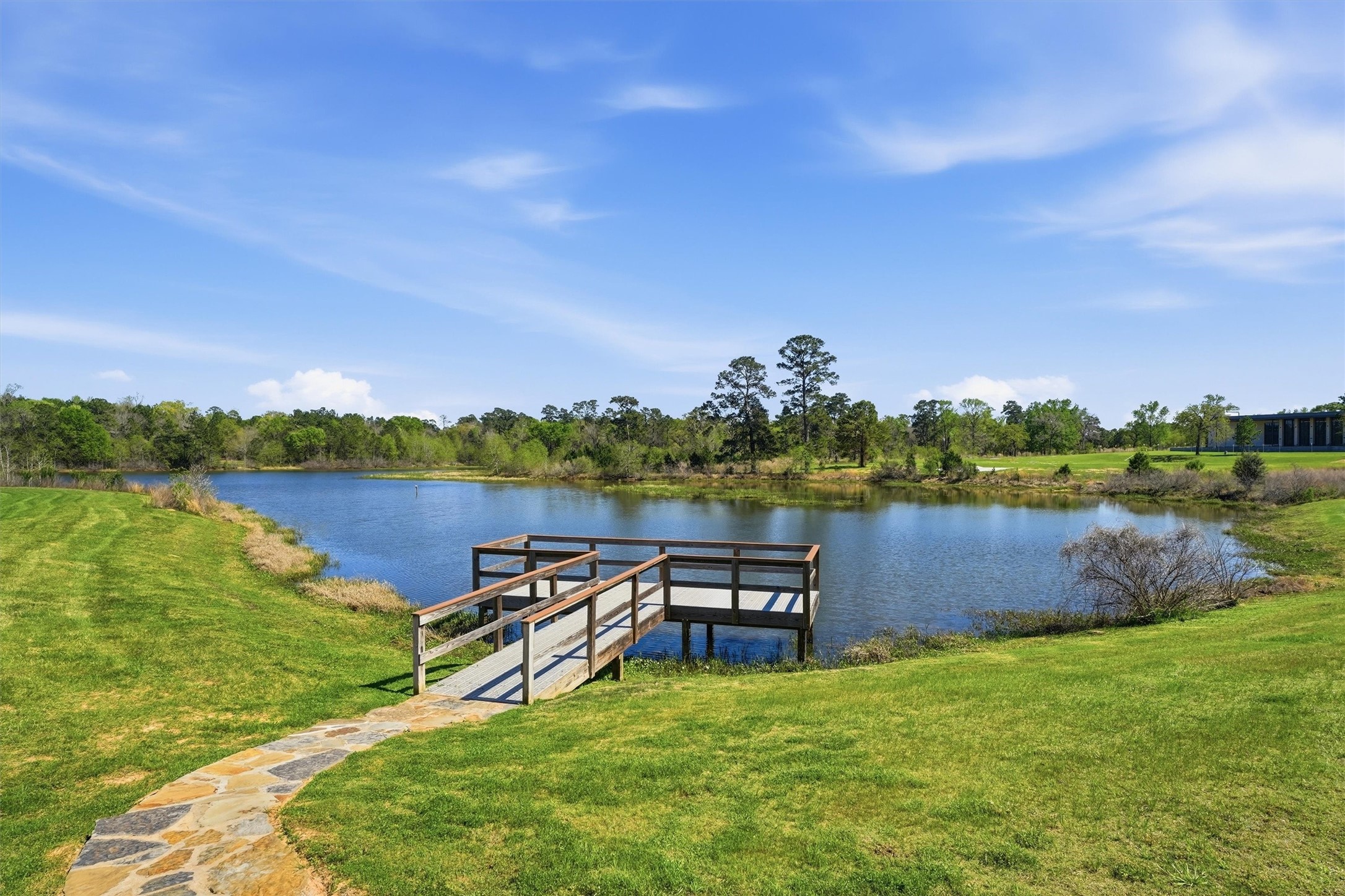 1338 Lakeside Crk Road Magnolia, TX 77354 - Photo 35 of 37 a view of a lake with lawn chairs and wooden fence