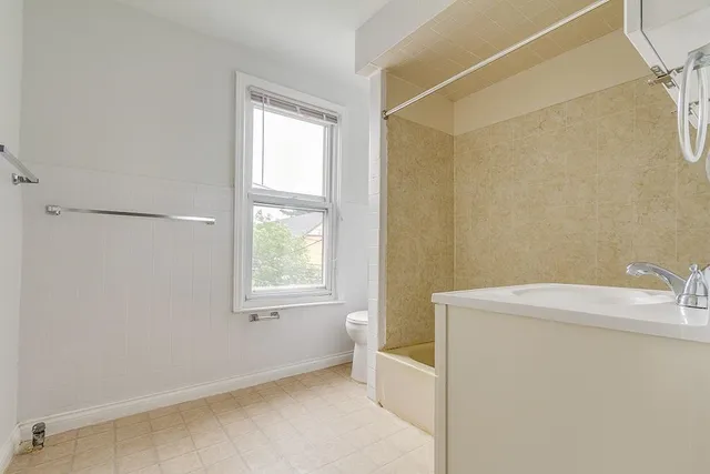 a bathroom with a sink a toilet and window