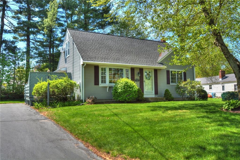 a front view of a house with a yard and trees