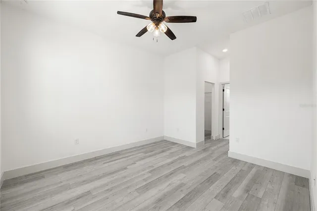 a view of a room with wooden floor and a ceiling fan