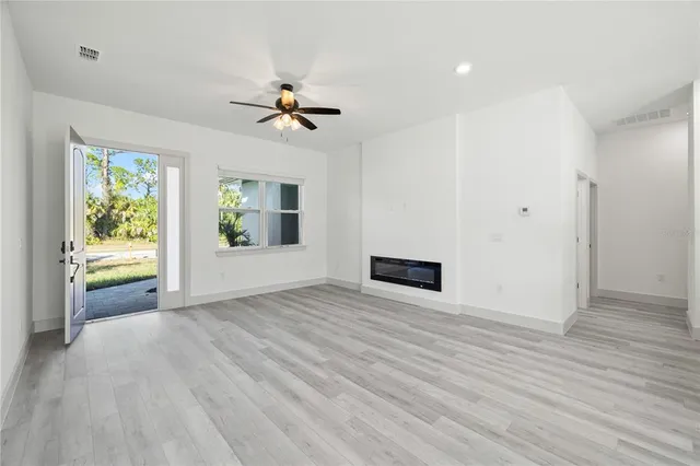 a view of an empty room with a window and wooden floor