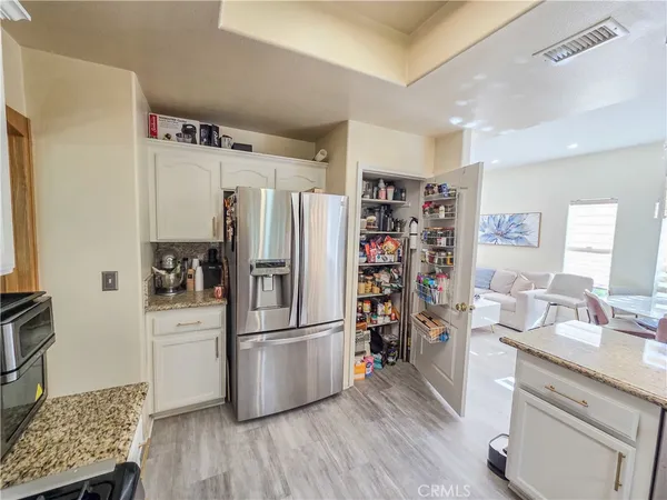 a kitchen with stainless steel appliances a refrigerator sink and wooden floor