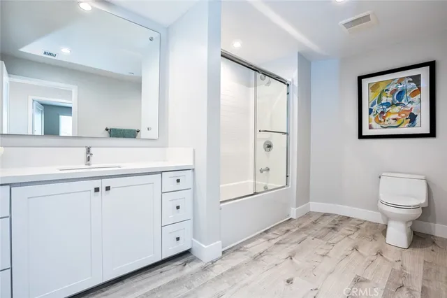 a spacious bathroom with a toilet a sink and a mirror