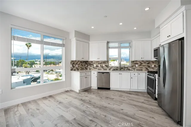 a kitchen with a refrigerator and white cabinets