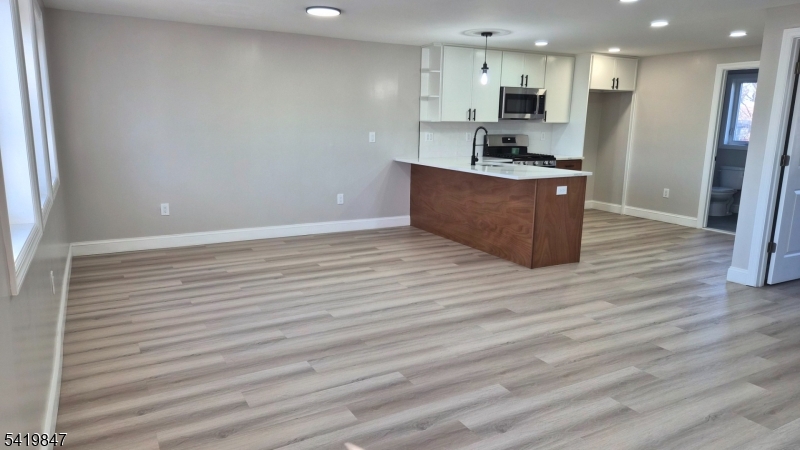 515 Maple Avenue, Unit 2 Rahway, NJ 07065 - Photo 2 of 13 a kitchen with stainless steel appliances wooden floor and large window