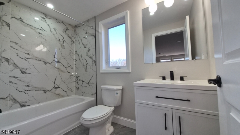515 Maple Avenue, Unit 2 Rahway, NJ 07065 - Photo 4 of 13 a bathroom with a sink toilet vanity granite tub and shower
