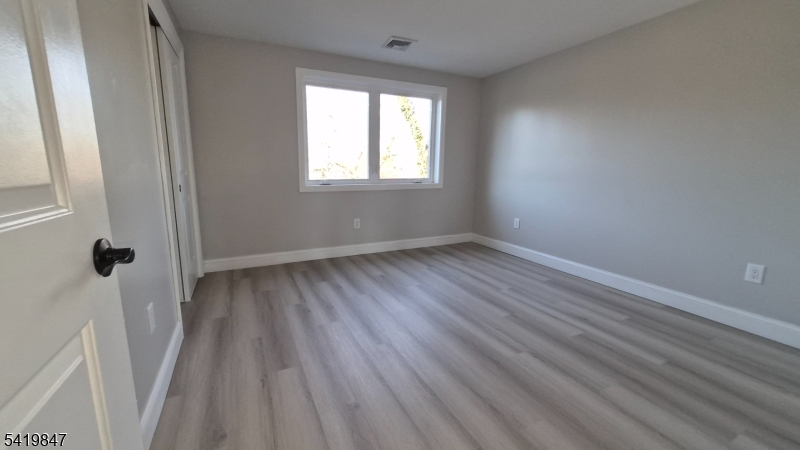 515 Maple Avenue, Unit 2 Rahway, NJ 07065 - Photo 5 of 13 a view of an empty room with wooden floor and a window