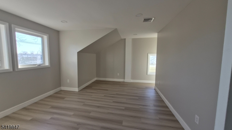 515 Maple Avenue, Unit 2 Rahway, NJ 07065 - Photo 8 of 13 a view of an empty room with wooden floor and a window