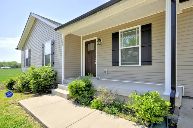 a front view of a house with a garden and yard