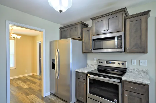a kitchen with a sink a window and wooden floor