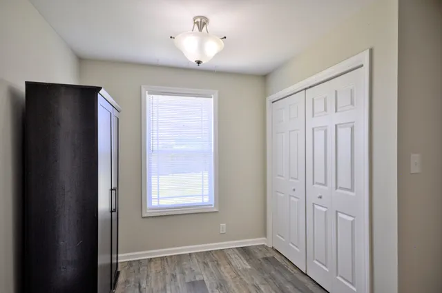 a view of a hallway with wooden floor and chandelier