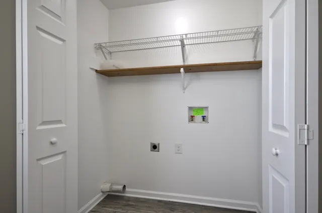 a view of a hallway with wooden floor and a chandelier