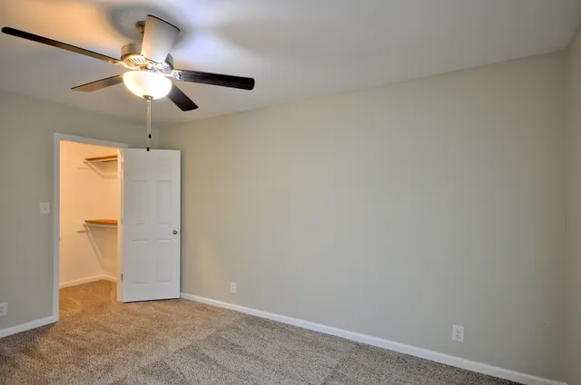 an empty room with a window and a fan