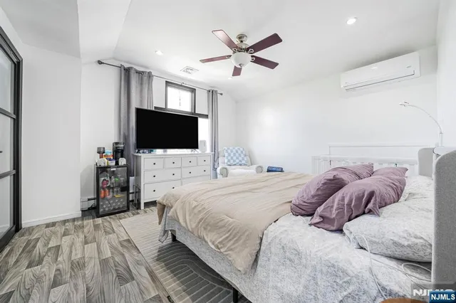 a bedroom with a large bed and a ceiling fan