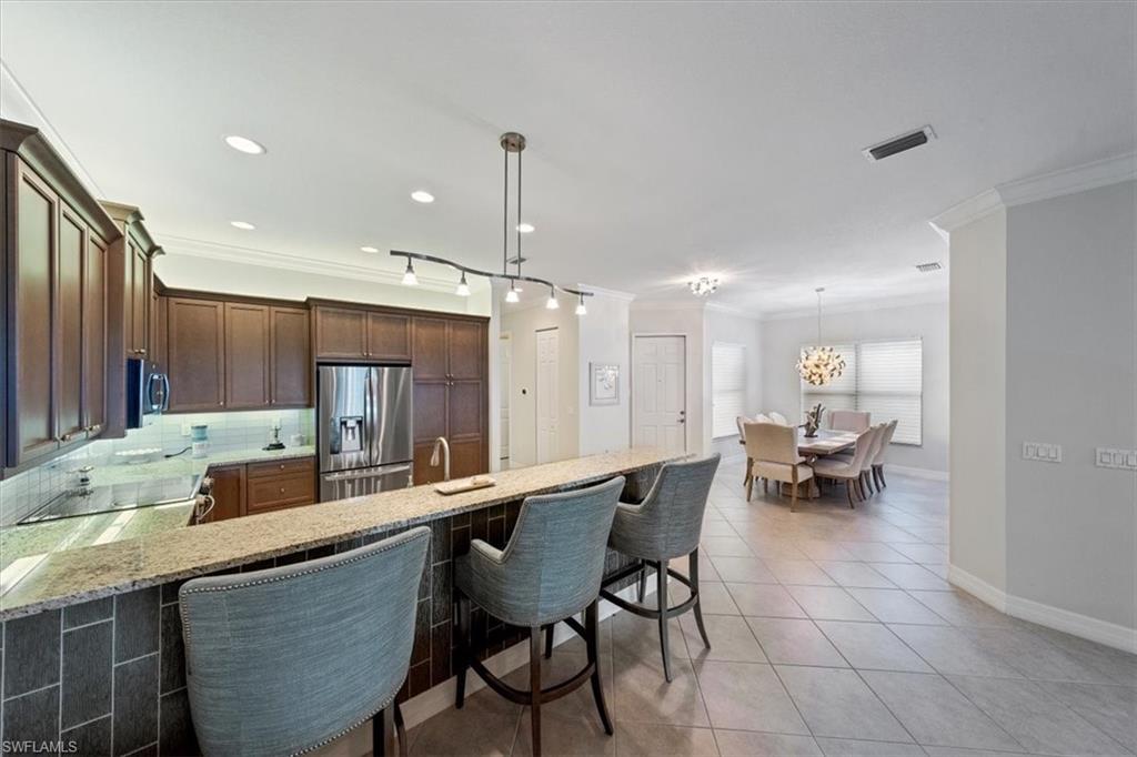 13479 Sumter Lane Naples, FL 34109 - Photo 11 of 35 a kitchen with a dining table chairs and white cabinets