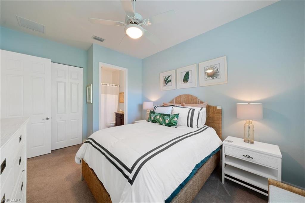 13479 Sumter Lane Naples, FL 34109 - Photo 21 of 35 a bedroom with a bed and a chandelier