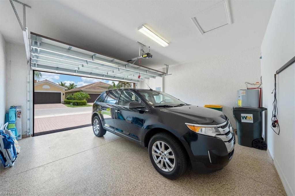13479 Sumter Lane Naples, FL 34109 - Photo 29 of 35 a car and bike parked in a garage