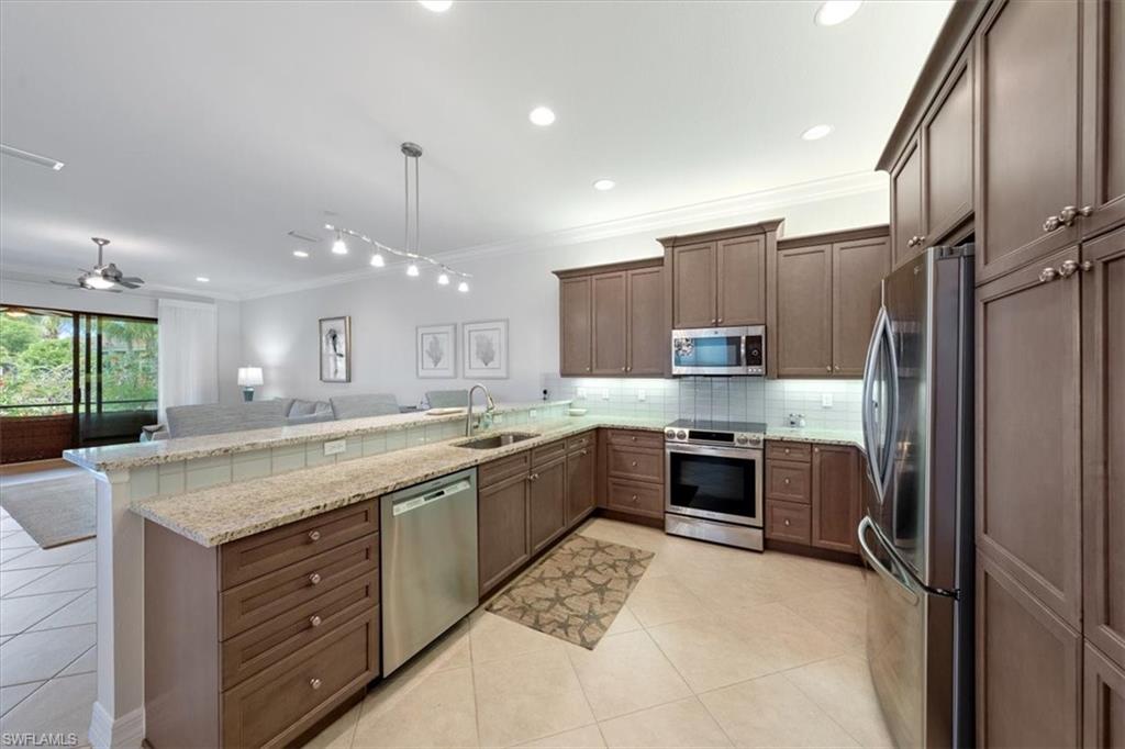 13479 Sumter Lane Naples, FL 34109 - Photo 9 of 35 a large kitchen with a large counter top a sink stainless steel appliances and cabinets