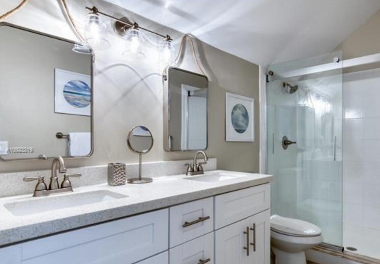 1605 Highway 1, Unit M2202 Jupiter, FL 33477 - Photo 14 of 19 a bathroom with a double vanity sink mirror double and shower