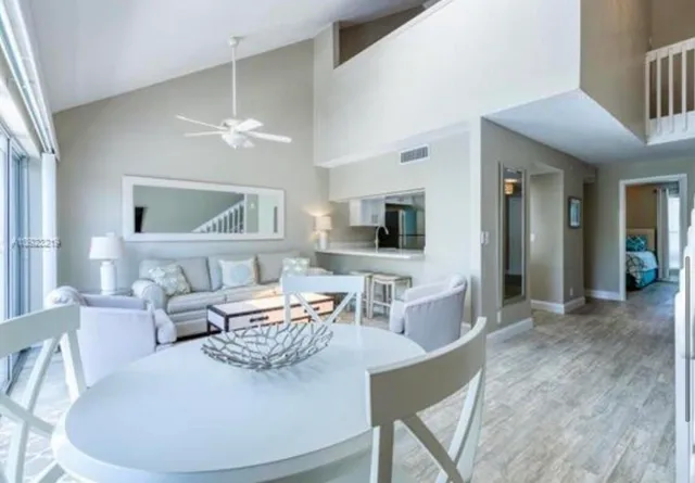 a living room with furniture a flat screen tv and kitchen view