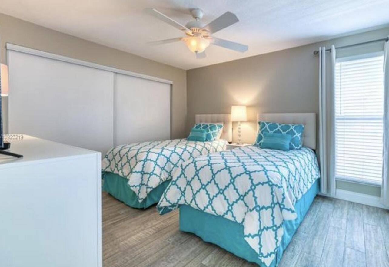 1605 Highway 1, Unit M2202 Jupiter, FL 33477 - Photo 9 of 19 a bedroom with a bed and a chandelier