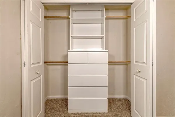 a view of walk in closet with empty racks