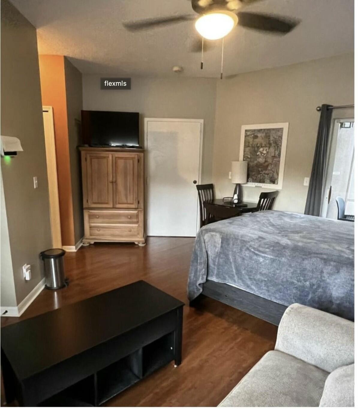 9898 Perfect Drive, Unit 19B Port St. Lucie, FL 34986 - Photo 2 of 10 a bedroom with a bed and a flat tv screen on dresser