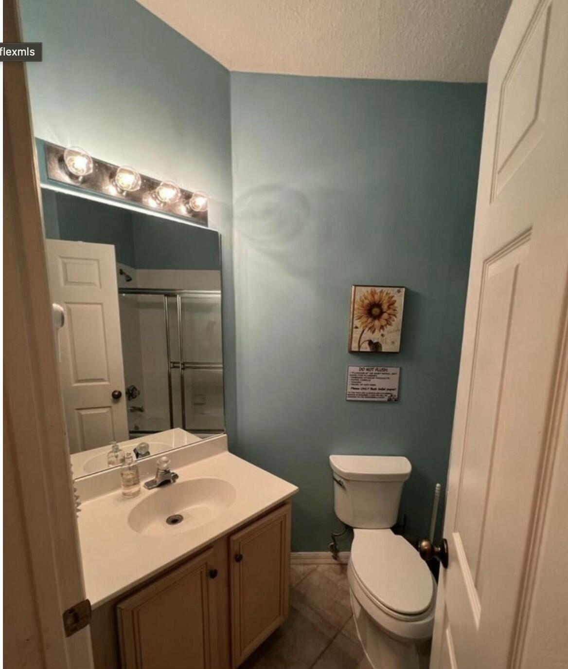 9898 Perfect Drive, Unit 19B Port St. Lucie, FL 34986 - Photo 7 of 10 a bathroom with a sink mirror vanity and toilet