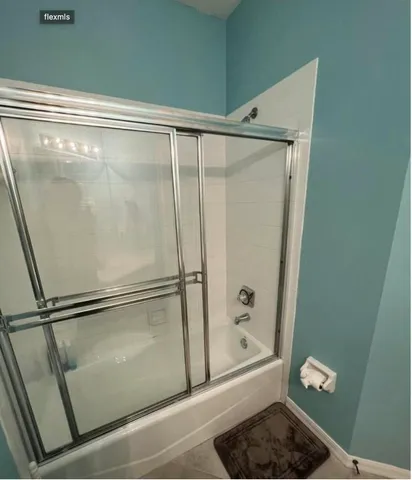 a bathroom with a glass shower door