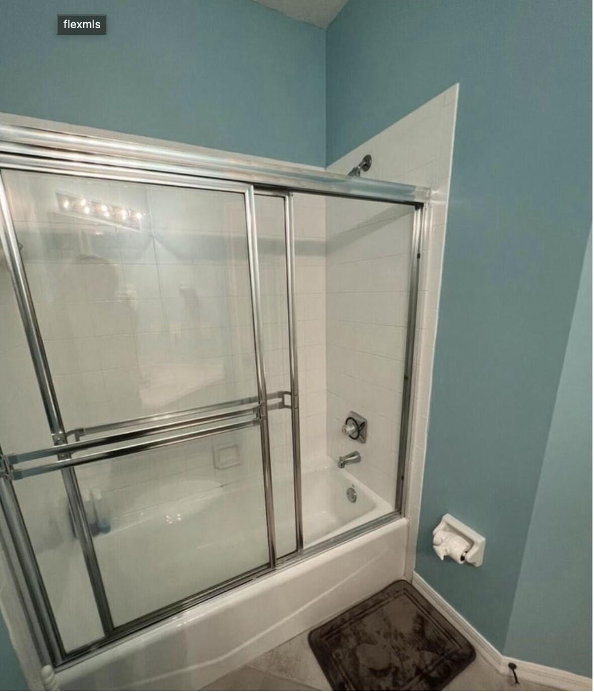 9898 Perfect Drive, Unit 19B Port St. Lucie, FL 34986 - Photo 8 of 10 a bathroom with a glass shower door