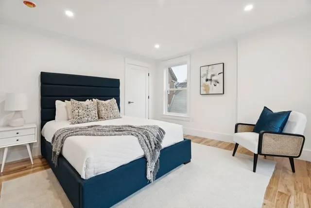 a spacious bedroom with a bed and chair