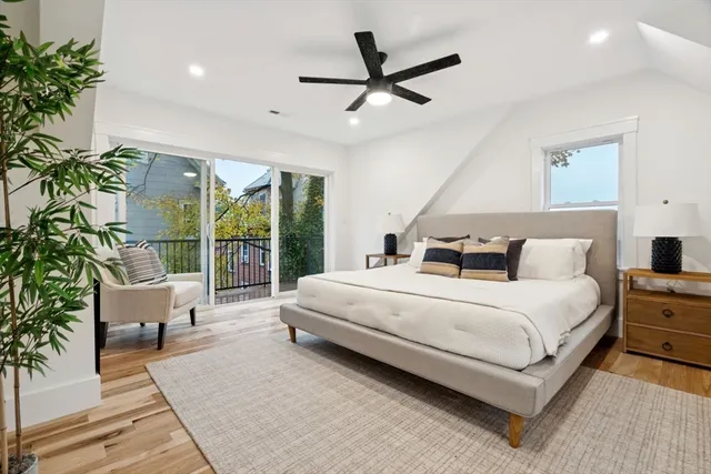 a spacious bedroom with a bed a couch and a potted plant