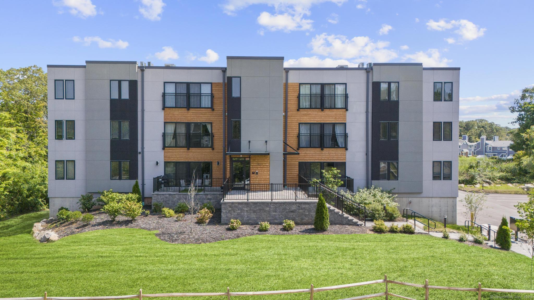 245 East Main Street, Unit 2 Branford, CT 06405 - Photo 1 of 40 a front view of a residential apartment building with a yard and plants
