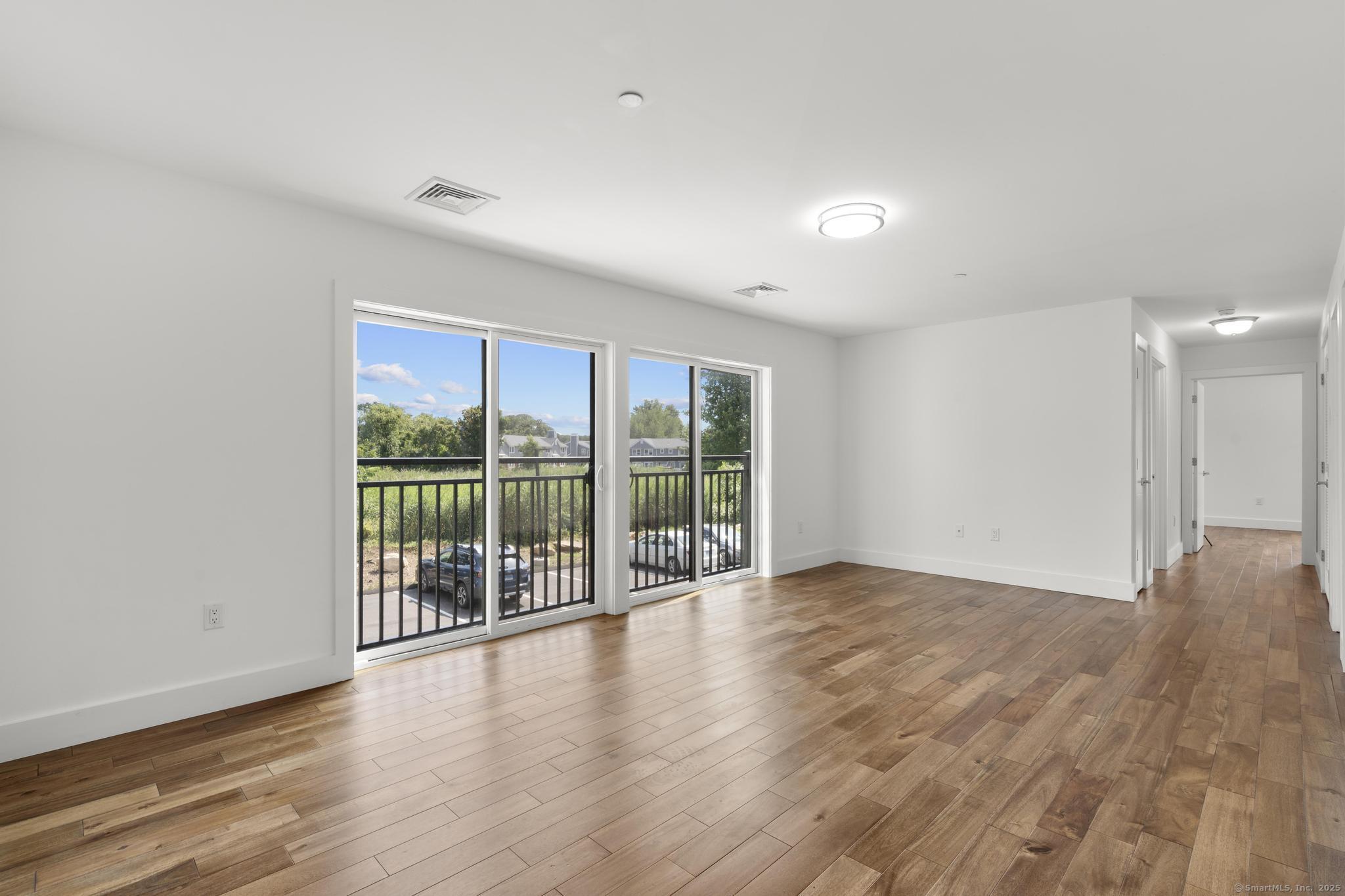 245 East Main Street, Unit 2 Branford, CT 06405 - Photo 16 of 40 a view of an empty room with wooden floor and a window