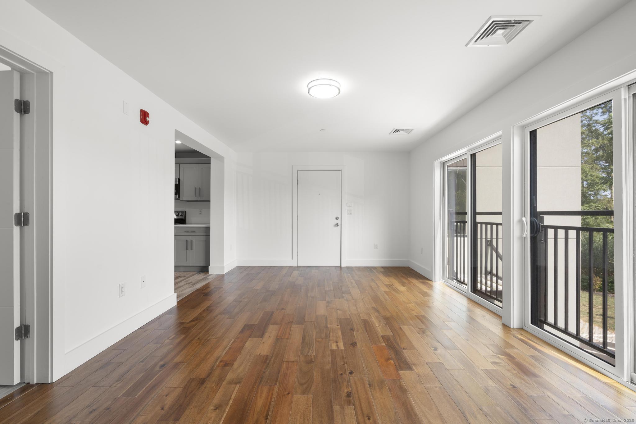 245 East Main Street, Unit 2 Branford, CT 06405 - Photo 18 of 40 an empty room with wooden floor and windows