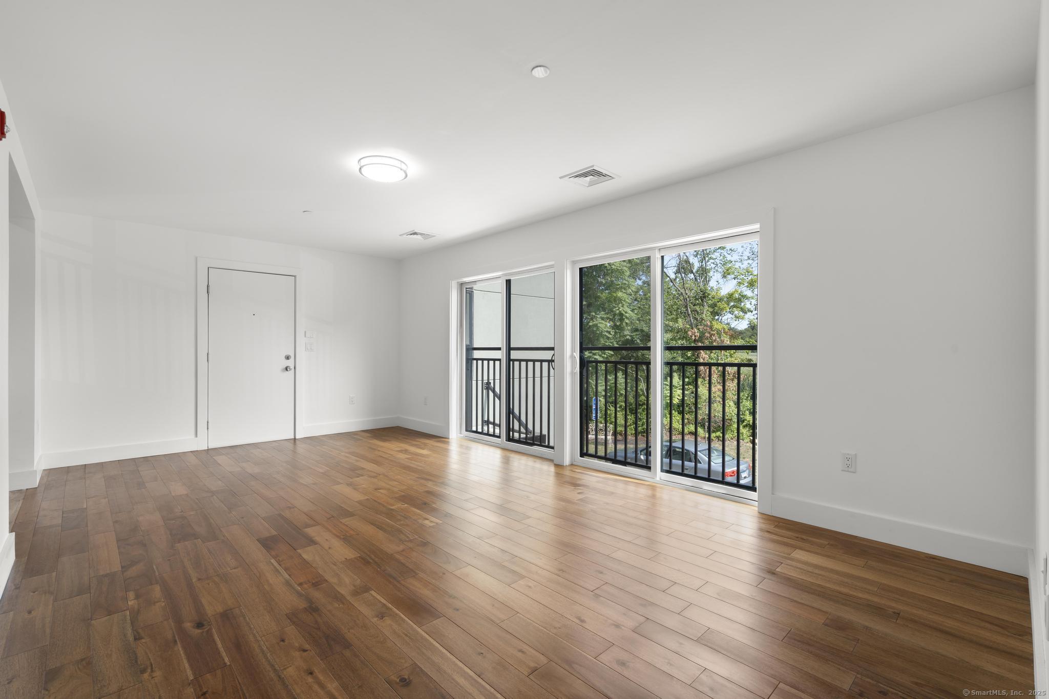 245 East Main Street, Unit 2 Branford, CT 06405 - Photo 19 of 40 a view of an empty room with wooden floor and a window