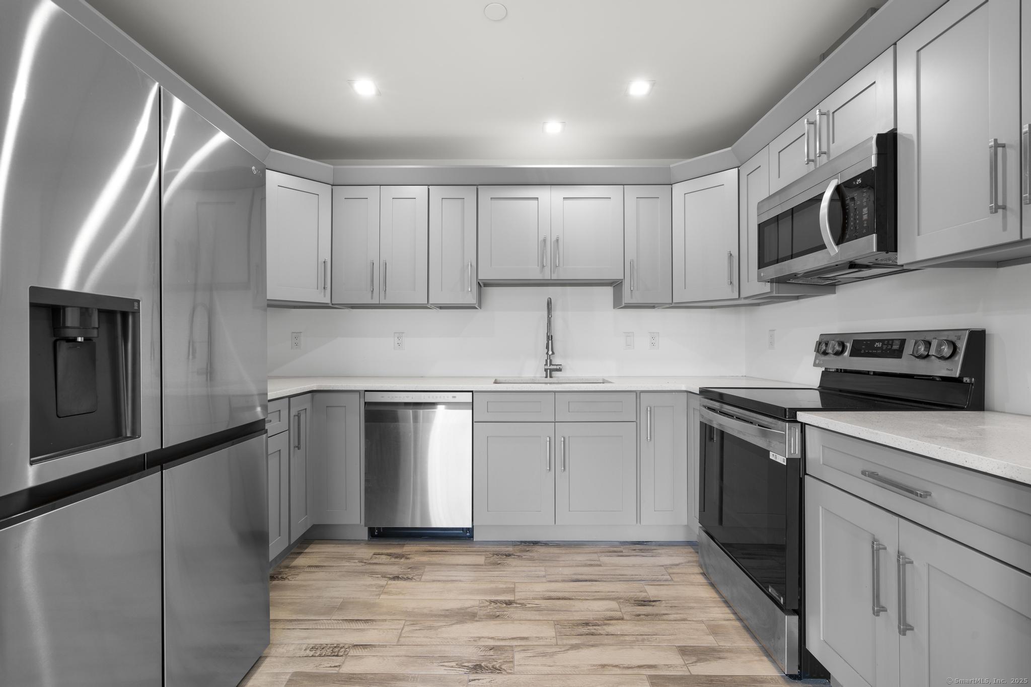 245 East Main Street, Unit 2 Branford, CT 06405 - Photo 20 of 40 a kitchen with stainless steel appliances granite countertop a stove a sink and a microwave