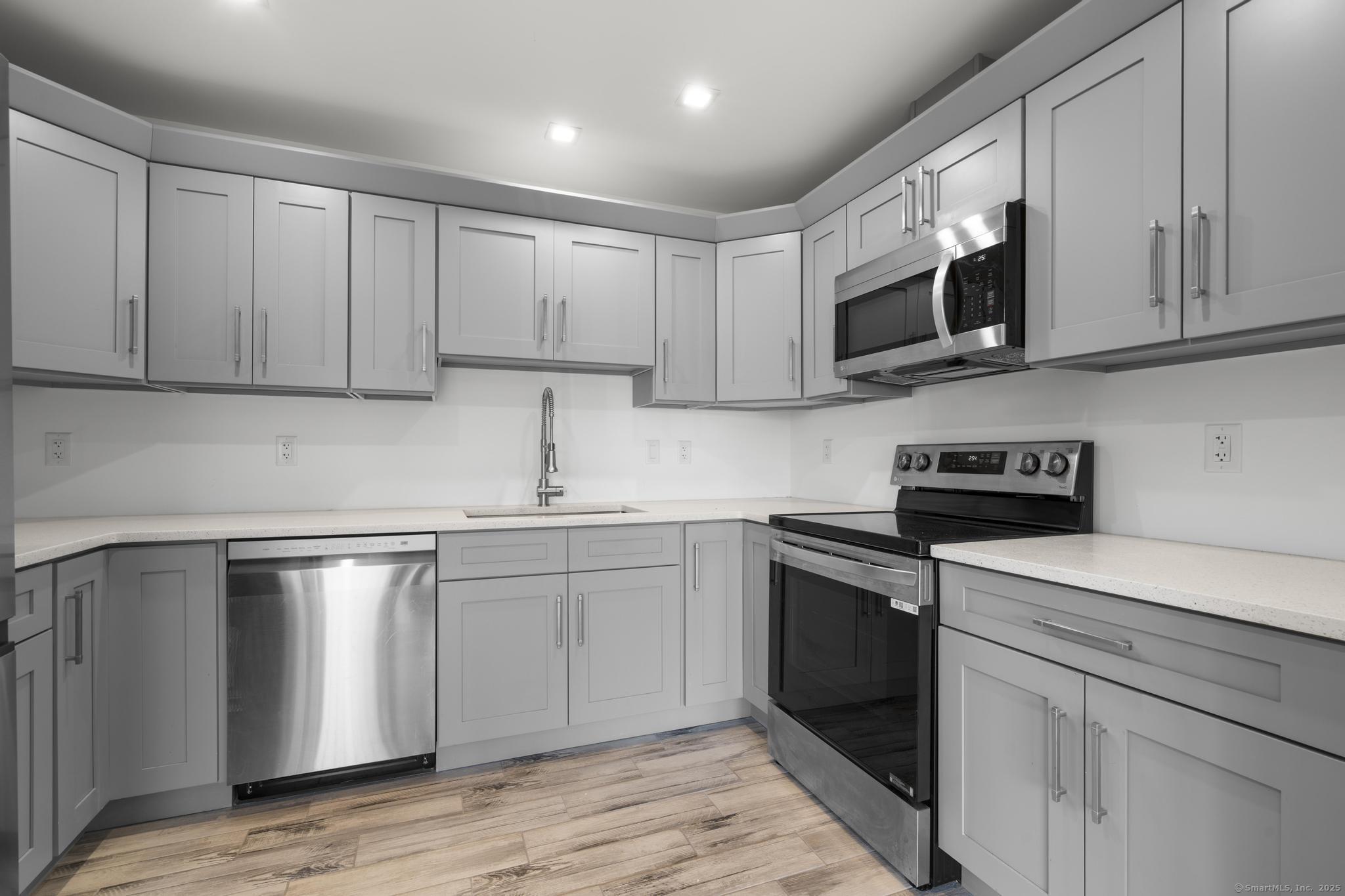 245 East Main Street, Unit 2 Branford, CT 06405 - Photo 21 of 40 a kitchen with stainless steel appliances granite countertop a sink and a stove top oven